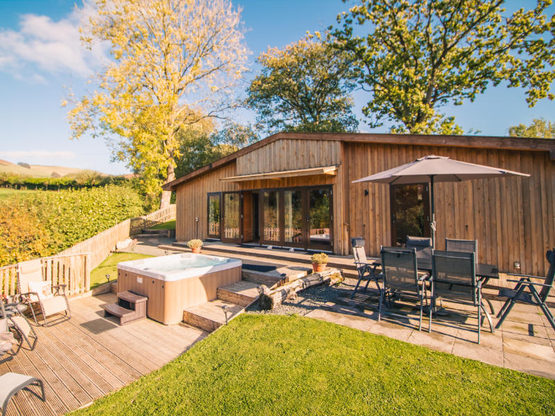 Ash Lodge. Outdoor area with Hot Tub, decking and sun loungers.